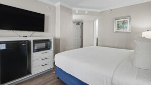 A hotel room with a bed, a flat-screen TV, a microwave, and a refrigerator. - Ocean View King Room + Beach Access + Lazy River (Myrtle Beach)