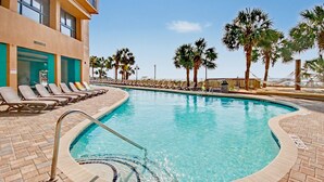 A swimming pool with lounge chairs and palm trees. - Oceanfront Studio w/ Two Queens + Beach & Pools (Myrtle Beach)
