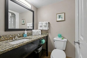 A bathroom with a granite countertop, a sink, a mirror, a toilet, and a towel rack. - Oceanfront Studio w/ Two Queens + Beach & Pools (Myrtle Beach)