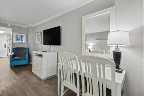 A room with a desk, a chair, a television, a lamp, and a blue chair. - Oceanfront Studio w/ Two Queens + Beach & Pools (Myrtle Beach)