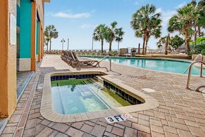 A swimming pool with a 3 FT depth marker, surrounded by lounge chairs and palm trees. - Oceanfront Studio w/ Two Queens + Beach & Pools (Myrtle Beach)