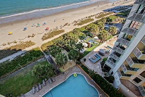 Ein Hotel mit Pool, Meerblick und einer Sitzgelegenheit im Freien.