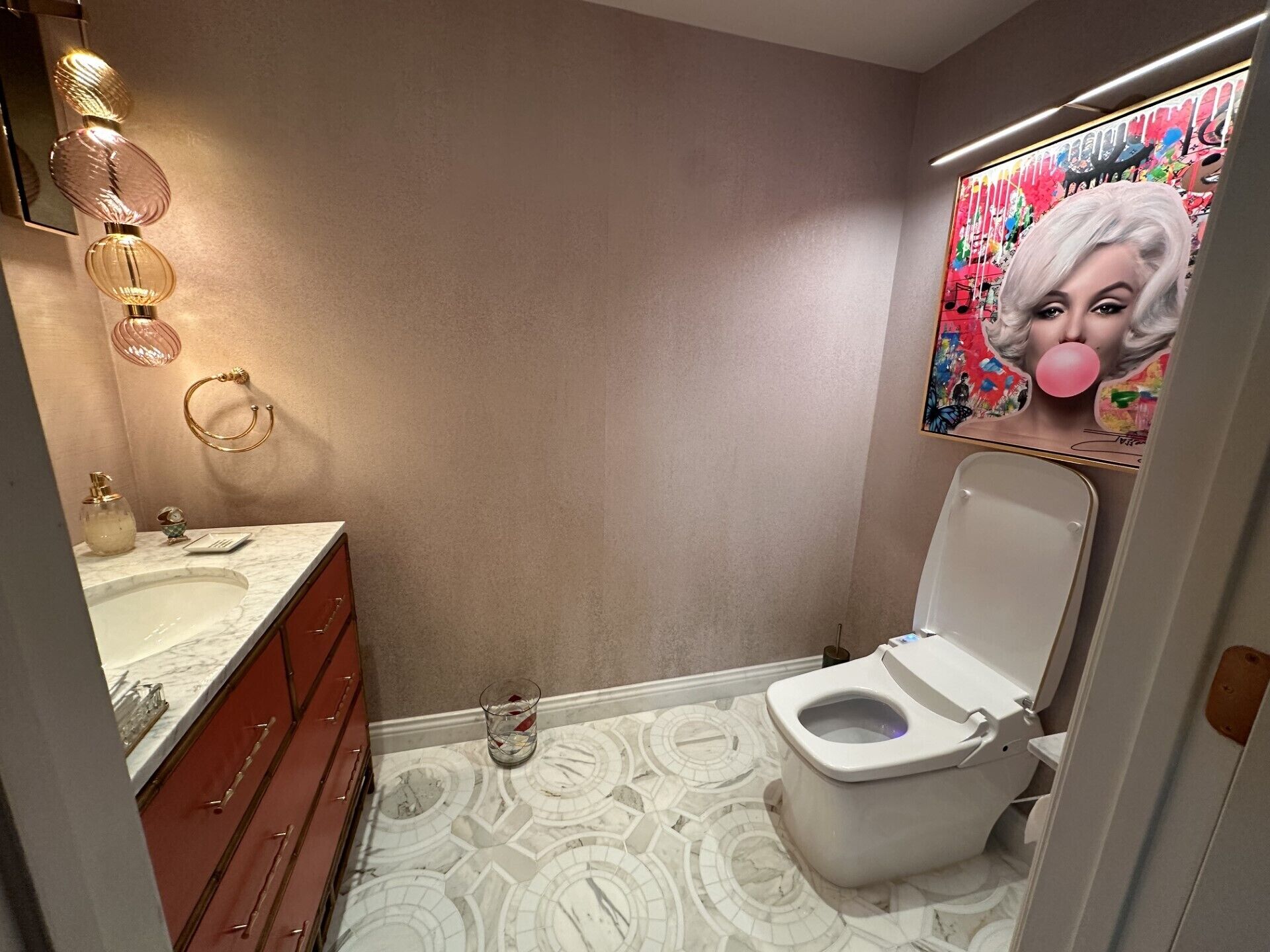 Ein Badezimmer mit Toilette, Waschbecken und Spiegel.