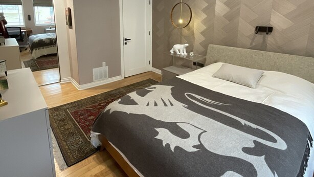 Ein modernes Schlafzimmer mit einem großen Bett, einem Schreibtisch und einem Sessel.