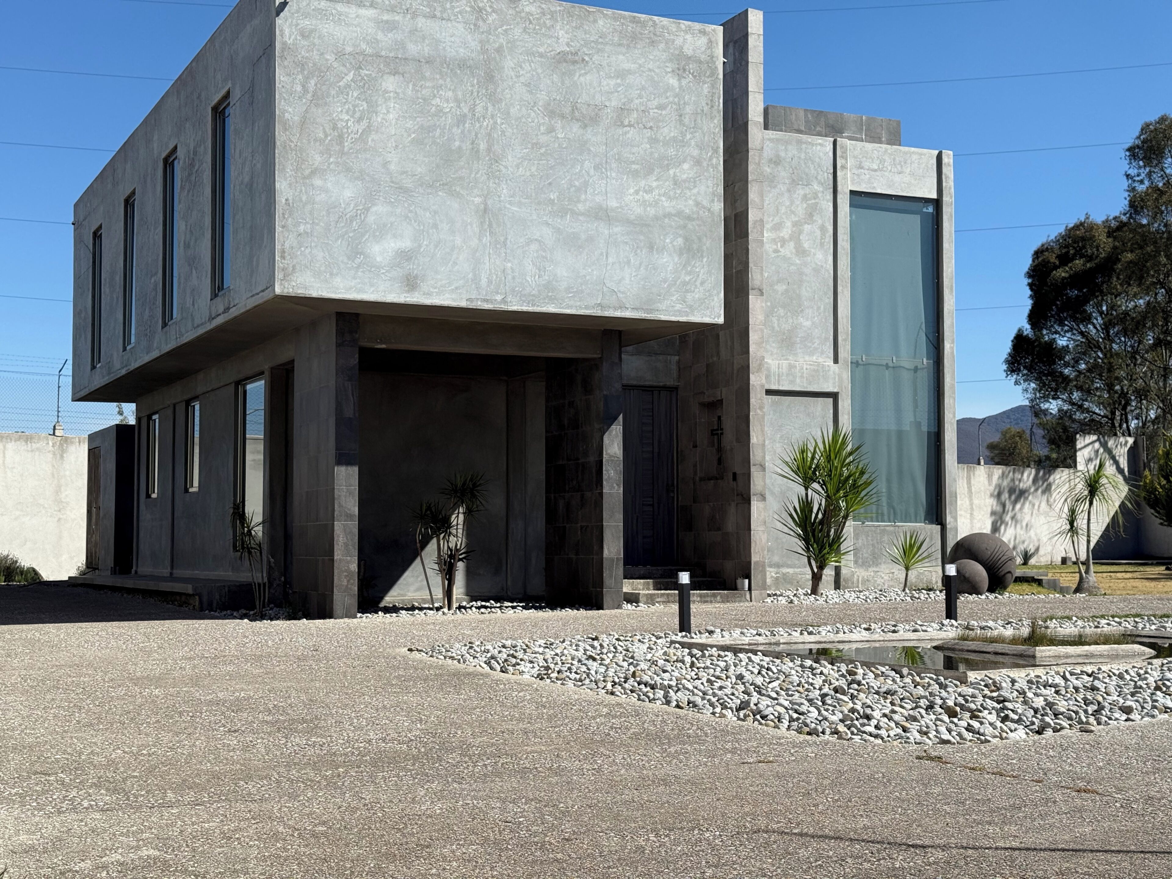 A modern building with a concrete facade, large windows, and a minimalist design.