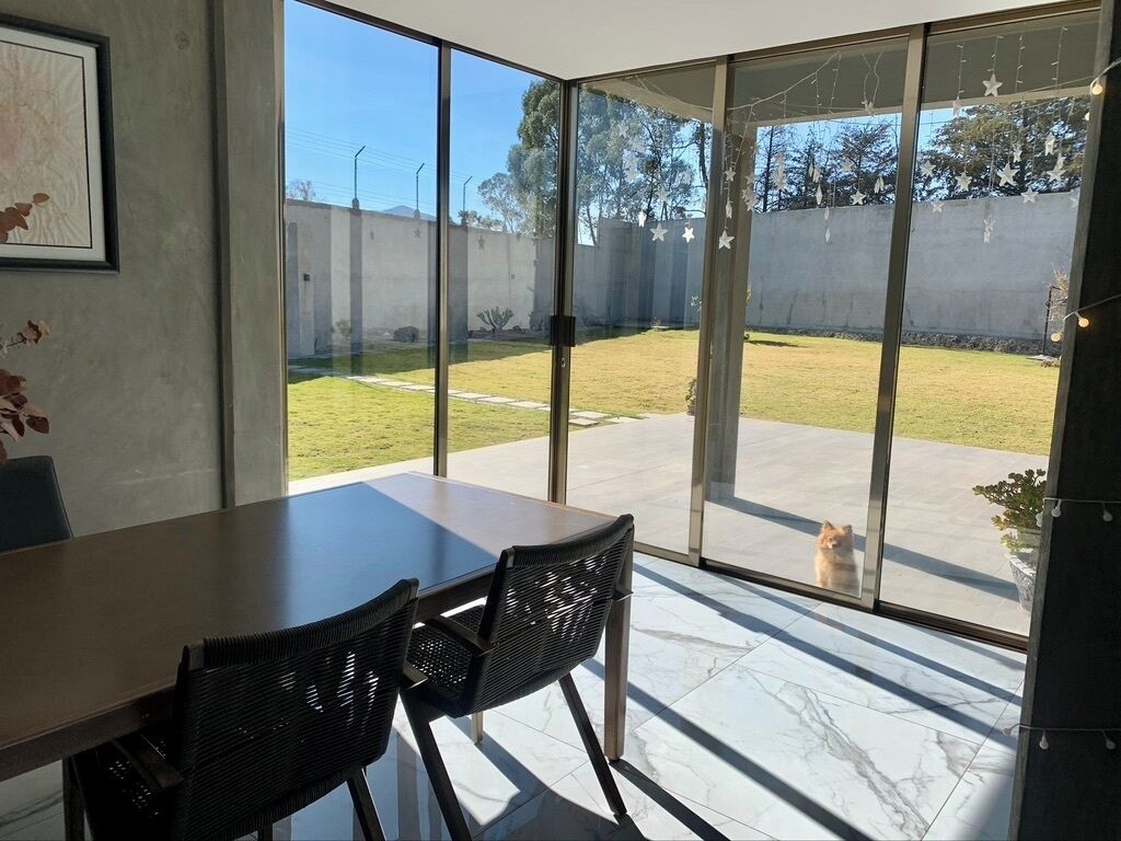 Et moderne værelse med en stor skydedør, der fører ud til en terrasse.