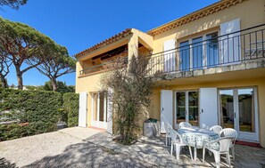 A two-story building with a balcony, outdoor seating area, and a garden. - Awesome home in Les Issambres with WiFi (les Issambres)