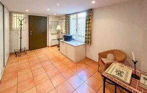 A room with a tiled floor, a desk with a lamp, a chair, and a window with curtains. - Awesome home in Les Issambres with WiFi (les Issambres)