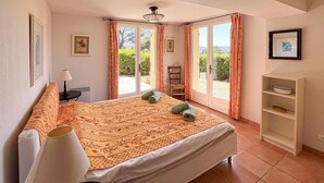 Un dormitorio con cama, una silla, un escritorio, una lámpara y una estantería.
