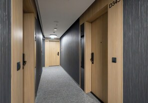 Ein Flur mit Holztüren, Teppichboden und einem Schild, das Zimmer D345 anzeigt.