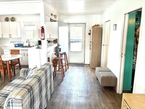 Una cocina compacta con comedor, un sofá y una banca.