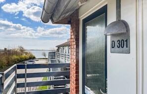 A residential building with a visible address sign 'D 301' and a view of a body of water in the background. - Awesome apartment in Faaborg with sauna (Faaborg)