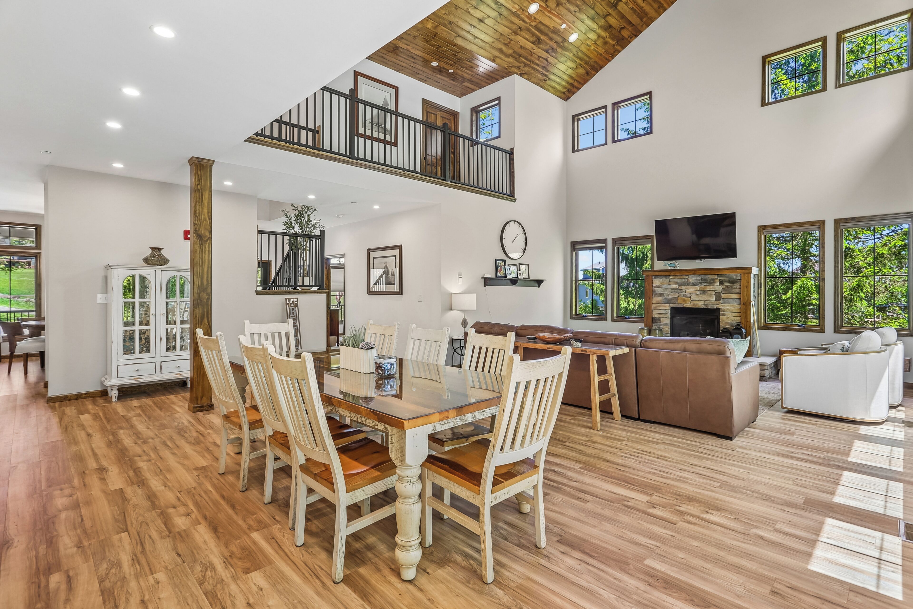 A spacious living area with a dining table, chairs, a fireplace, and a TV.