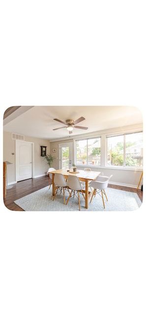 A dining area with a table, chairs, a ceiling fan, and large windows. - Cape Cod ať South River USNA Commissioning Week! (Riva)