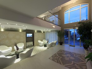 A modern hotel lobby with a seating area, a TV screen, and a large window. - Agusta Spa Hotel (Veliko Tarnovo)