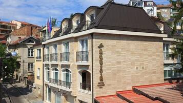 A multi-story hotel with balconies, a stone facade, and a sign indicating it is a hotel and spa.