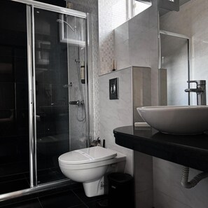 A modern bathroom with a glass shower enclosure, a white toilet, and a large vessel sink. - Agusta Spa Hotel (Veliko Tarnovo)
