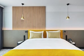 A hotel room with a bed, two bedside tables, a wall-mounted telephone, and two pendant lights. - The Hotel Katowice (Katowice)
