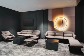 Un salon moderne avec un canapé d’angle, une table basse et un téléviseur fixé au mur.
