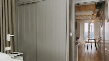 Une chambre comprenant un lit, une table de chevet, une armoire et donnant sur un coin repas avec une table et des chaises.