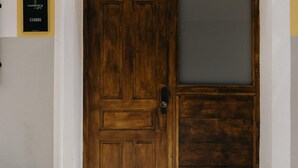 Una porta doppia in legno con un vetro, una maniglia in metallo e un piccolo gradino.