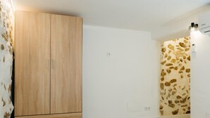 Una camera da letto con un armadio in legno, una parete decorata e un letto.