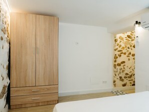 Une chambre à coucher avec une armoire en bois, un mur à motifs et un lit.