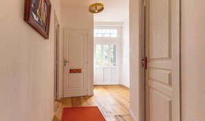 A hallway with wooden flooring, white doors, and a red rug. - Les Amandiers - CEYRAT (CEYRAT)