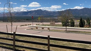 A road intersection with a stop sign, a pedestrian crossing sign, and a sign for Stonewater. - Mountain Views, Air Force Academy, Hot Tub, Pet Friendly, Hiking, Trails, Dining (Colorado Springs)