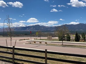 A road intersection with a stop sign, a pedestrian crossing sign, and a sign for Stonewater. - Mountain Views, Air Force Academy, Hot Tub, Pet Friendly, Hiking, Trails, Dining (Colorado Springs)