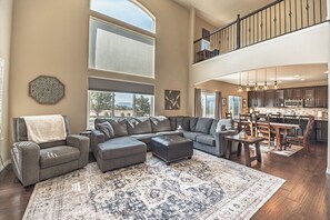 A spacious living area with a sectional sofa, ottoman, and a large rug. - Mountain Views, Air Force Academy, Hot Tub, Pet Friendly, Hiking, Trails, Dining (Colorado Springs)