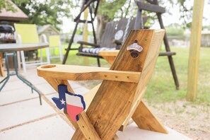 A wooden chair with a Texas state flag design and a metal plate labeled 'TEXAS' on the backrest. - 5 Bedroom Mid Term Rental in Bryan "The WHOOP" (Bryan)