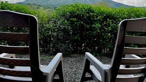Duas cadeiras de frente para uma montanha, com vista do céu.
