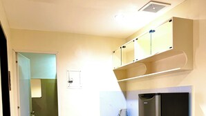 Una cocina compacta con refrigerador, lavamanos y microondas.