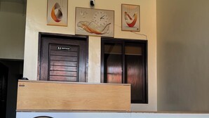 Un mostrador de recepción con un logotipo, un reloj y una puerta que indica 'OFICINA'.