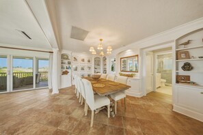A spacious kitchen with a large dining table, white cabinetry, and a view to the outside. - Waterfront Marathon FL Home w/ Pool, 75' Dock, Near Sombrero Beach, Pet Friendly (Marathon)