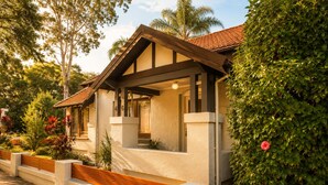 Une maison moderne dotée d’un porche abrité, d’une plaque portant le numéro « 46 » et d’un jardin bien entretenu.