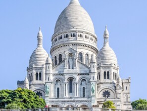 Ein großes, mit einer Kuppel versehenes Gebäude mit mehreren Türmen und Statuen.