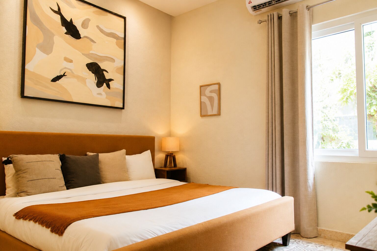Habitación de hotel con cama, mesita de noche, aire acondicionado de pared, ventana con cortinas y un cuadro.