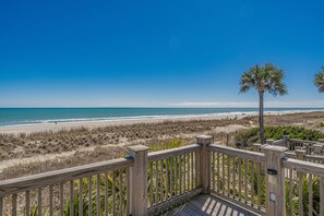 Eine Holterrasse mit Blick auf einen Strand und einen klaren Himmel.