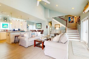 A spacious living area with a kitchen, a staircase, and a dining area. - LCV33 Shared Pool, Private Hot Tub,Propane Grill (Port Aransas)