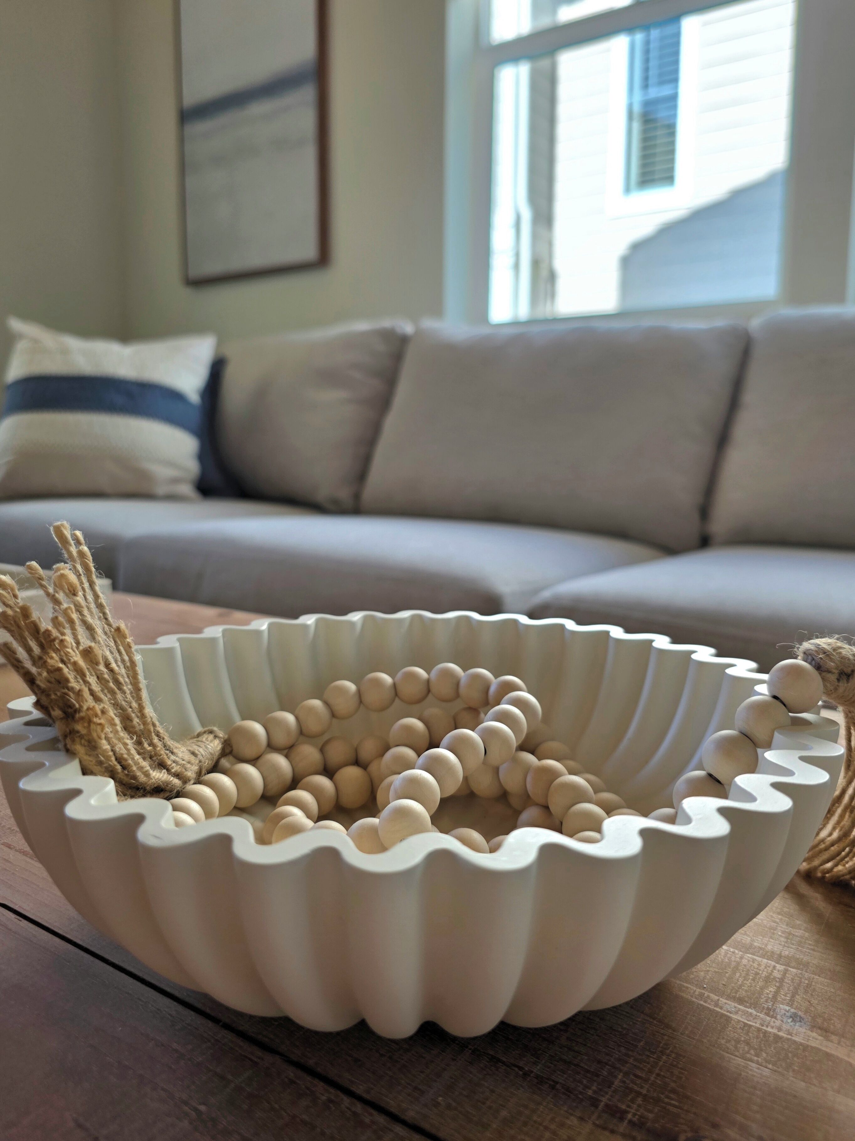 Uma tigela branca e recortada com bolas de madeira sobre uma mesa de madeira.