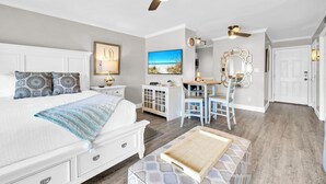 Une chambre à coucher avec un lit, des tables de chevet, un bureau et une chaise.