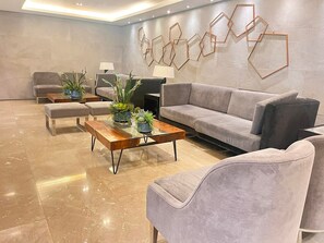 Ein modernes Wohnzimmer mit einer Couch, Sesseln, einem Couchtisch und Wanddekoration.