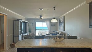 A kitchen with a large island, dark cabinetry, and a view to the outside. - Surfwatch II 204 - Oceanfront in Surfside Beach (Surfside Beach)