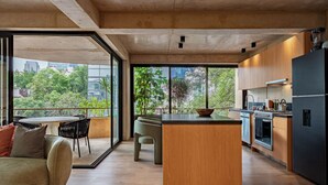 Una cocina moderna con una isla central, ventanas amplias y una zona de comedor con sofá y sillas.