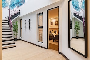 A modern interior with a staircase, a bed, and a large mirror reflecting the room. - Spacious Group Getaway with Private Terrace & Grill (Mexico City)