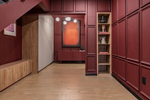 A hallway with a wooden bench, a wall-mounted light fixture, and a shelf with books and decorative items. - Spacious Group Getaway with Private Terrace & Grill (Mexico City)