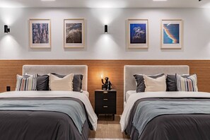 A modern bedroom with two beds, wooden headboards, and framed artwork on the wall. - Spacious Group Getaway with Private Terrace & Grill (Mexico City)