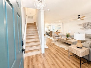 Eine Treppe führt zu einem Wohnbereich mit einer Couch, einem Couchtisch und einer Lampe.